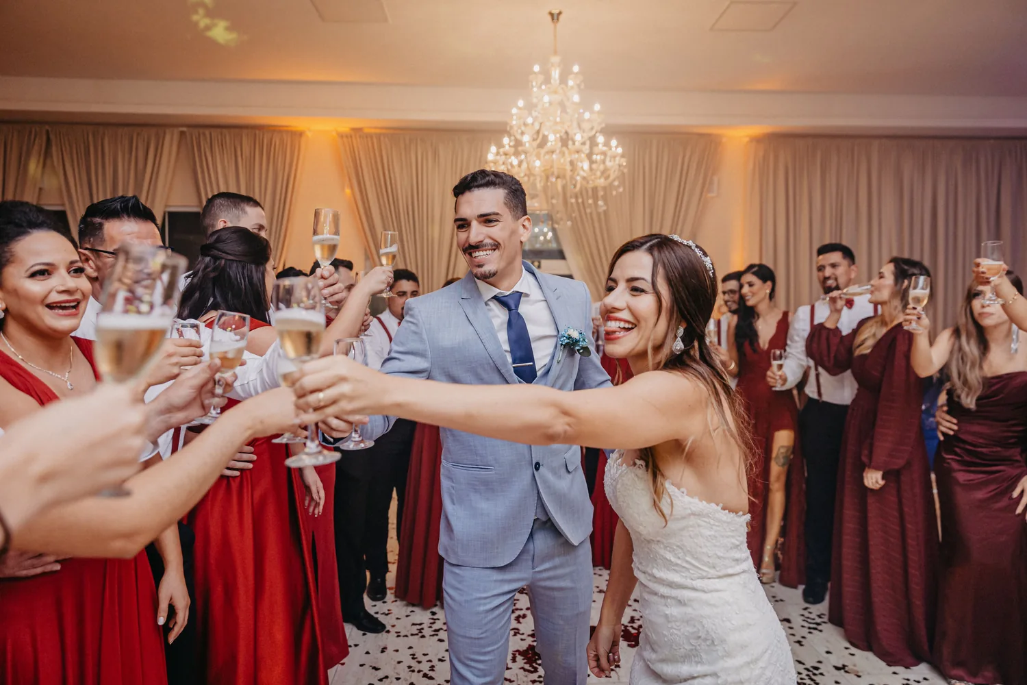 Wedding guests and newlyweds raising their glasses together